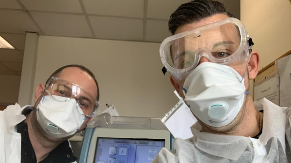 Baxter technicians wearing personal protective equipment work inside a healthcare facility in Italy